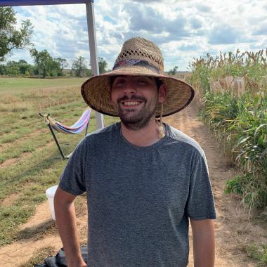 Man in field w/ woven hat